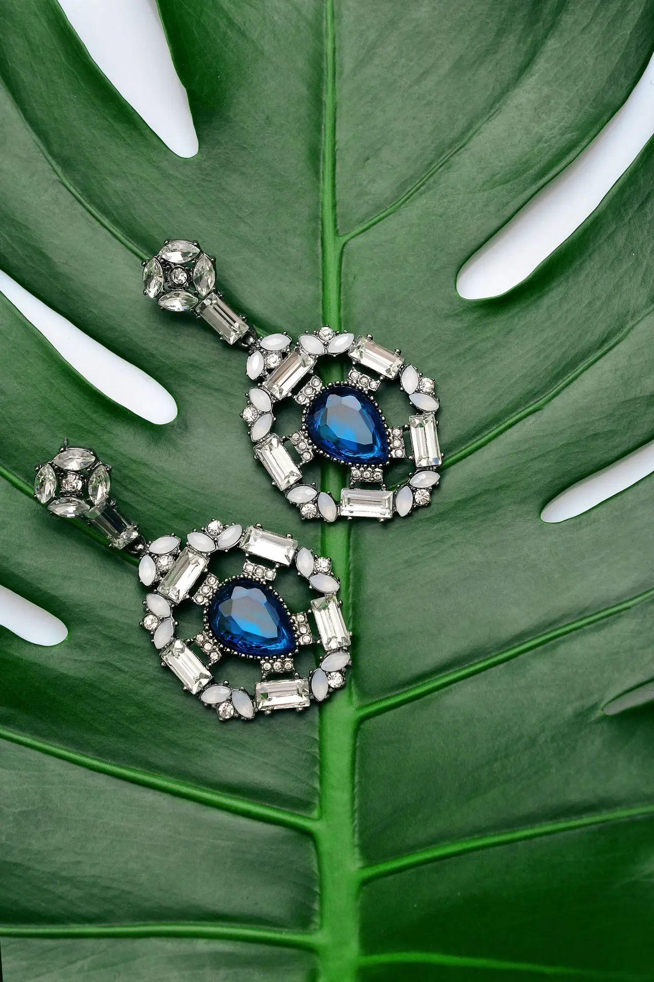 pair of silver-colored earrings with blue gemstone